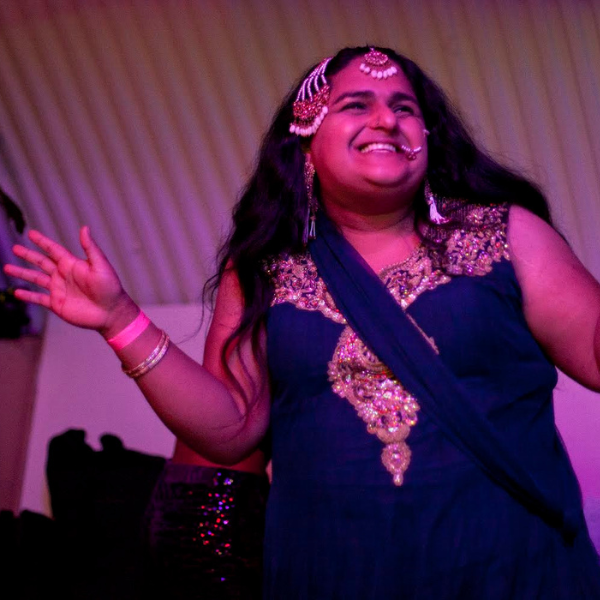 Shivanya performs under the alias of Bin Pankh Ki Pari ("an angel without wings" in Hindi/Urdu). She is a queer South Asian woman who loves to dance to a range of Desi music, incorporating multiple languages into her routine. 