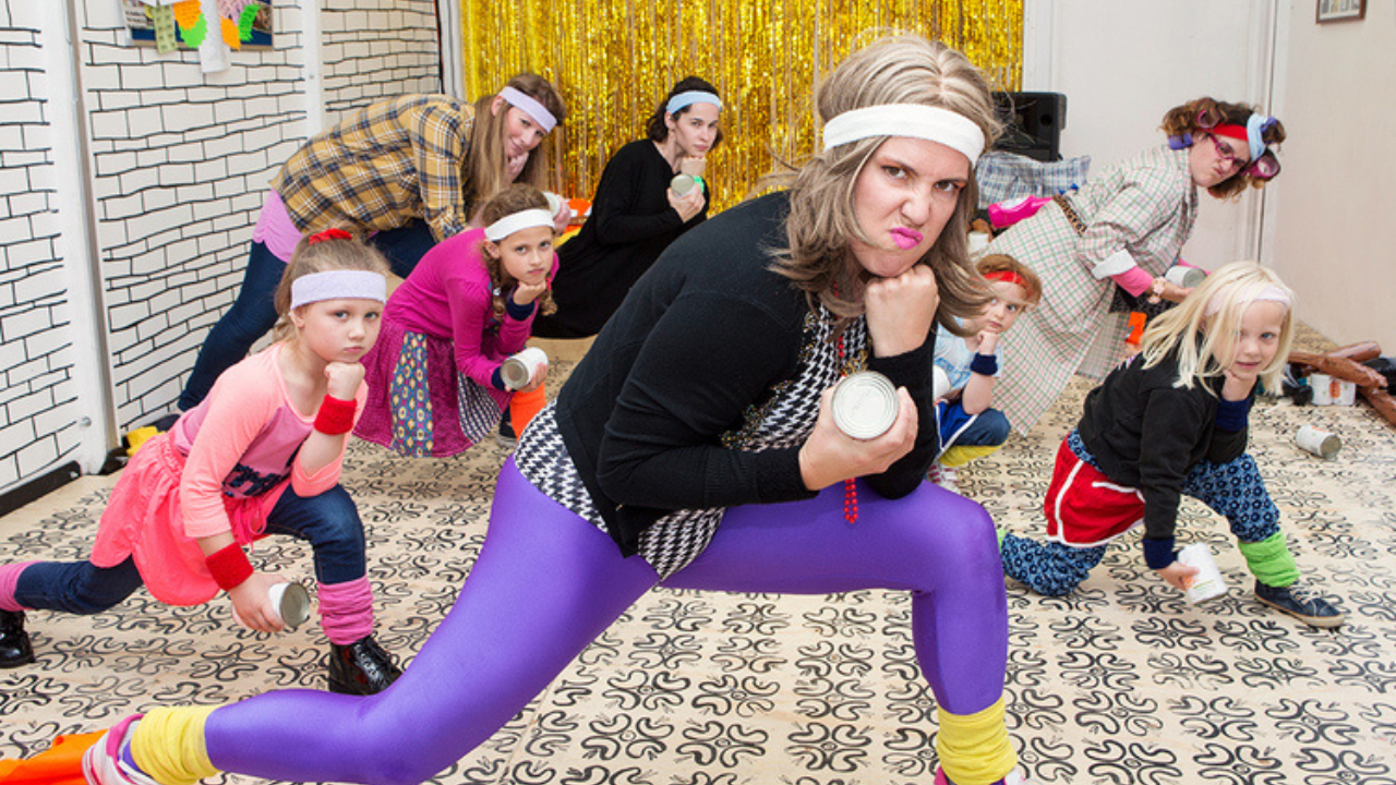 Tracey is dressed in Lycra and lunging onto one knee with her elbow resting on her knee and her chin resting on her fist. There are other aerobic fanatics of all ages around her all wearing headbands, ankle warmers and wrist bands. They are all doing the same pose as Tracey and all look fierce.