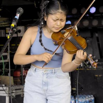 Sara Maldonado Lema playing the violin on a stage.