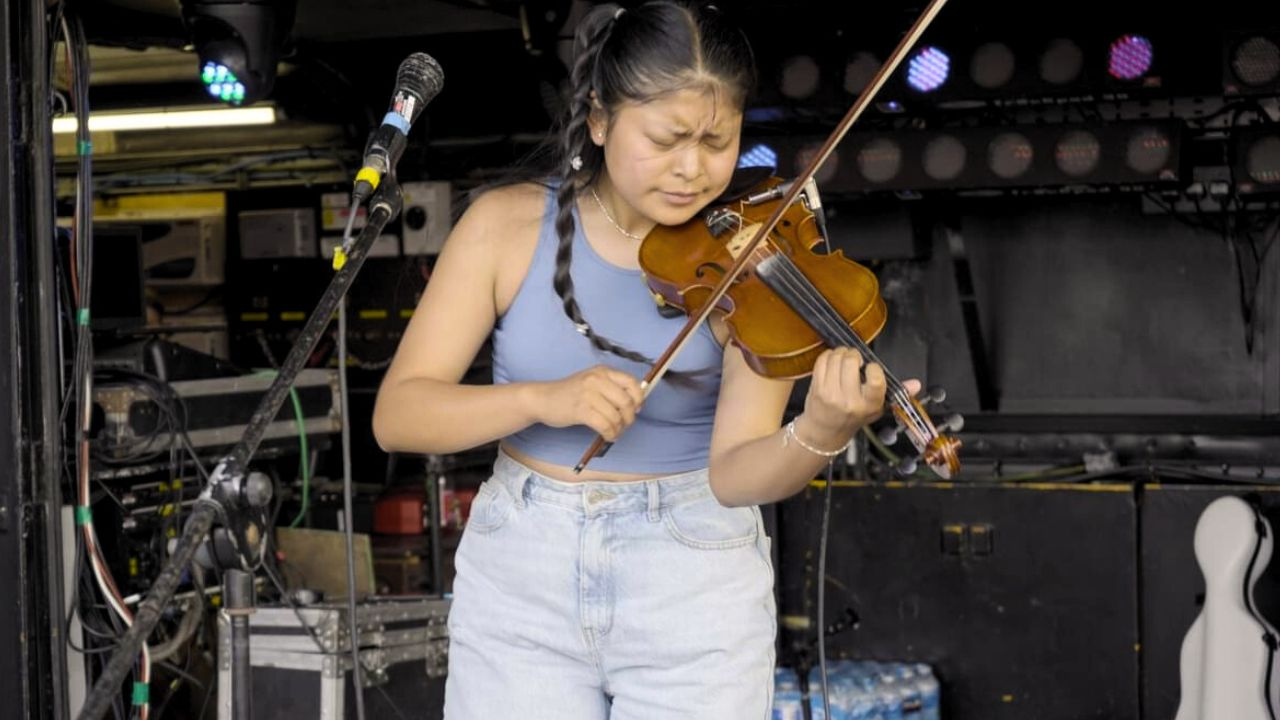 Sara Maldonado Lema playing the violin on a stage.